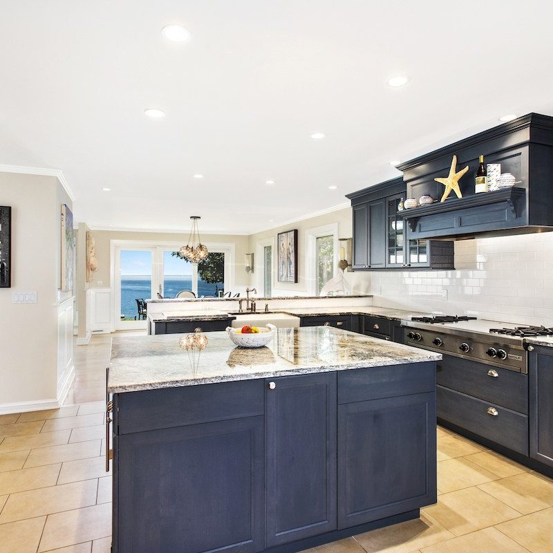 Exquisite kitchen with navy cabinets and granite countertops.