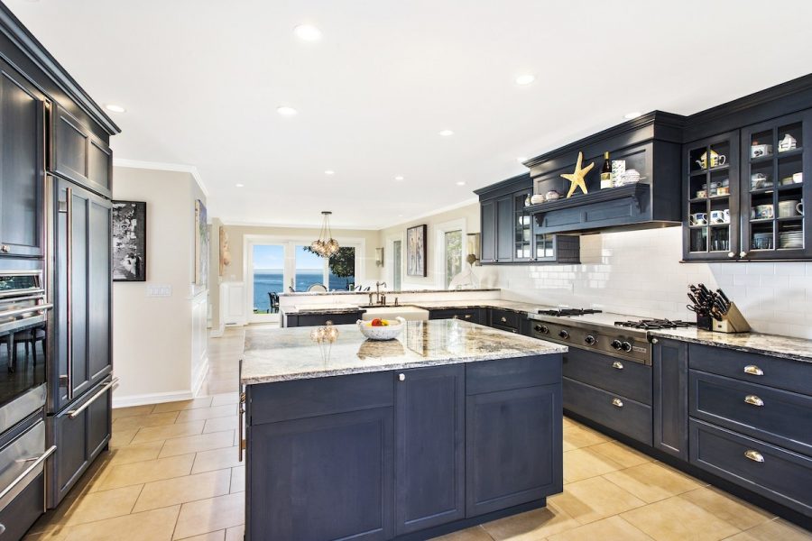 Exquisite kitchen with navy cabinets and granite countertops.